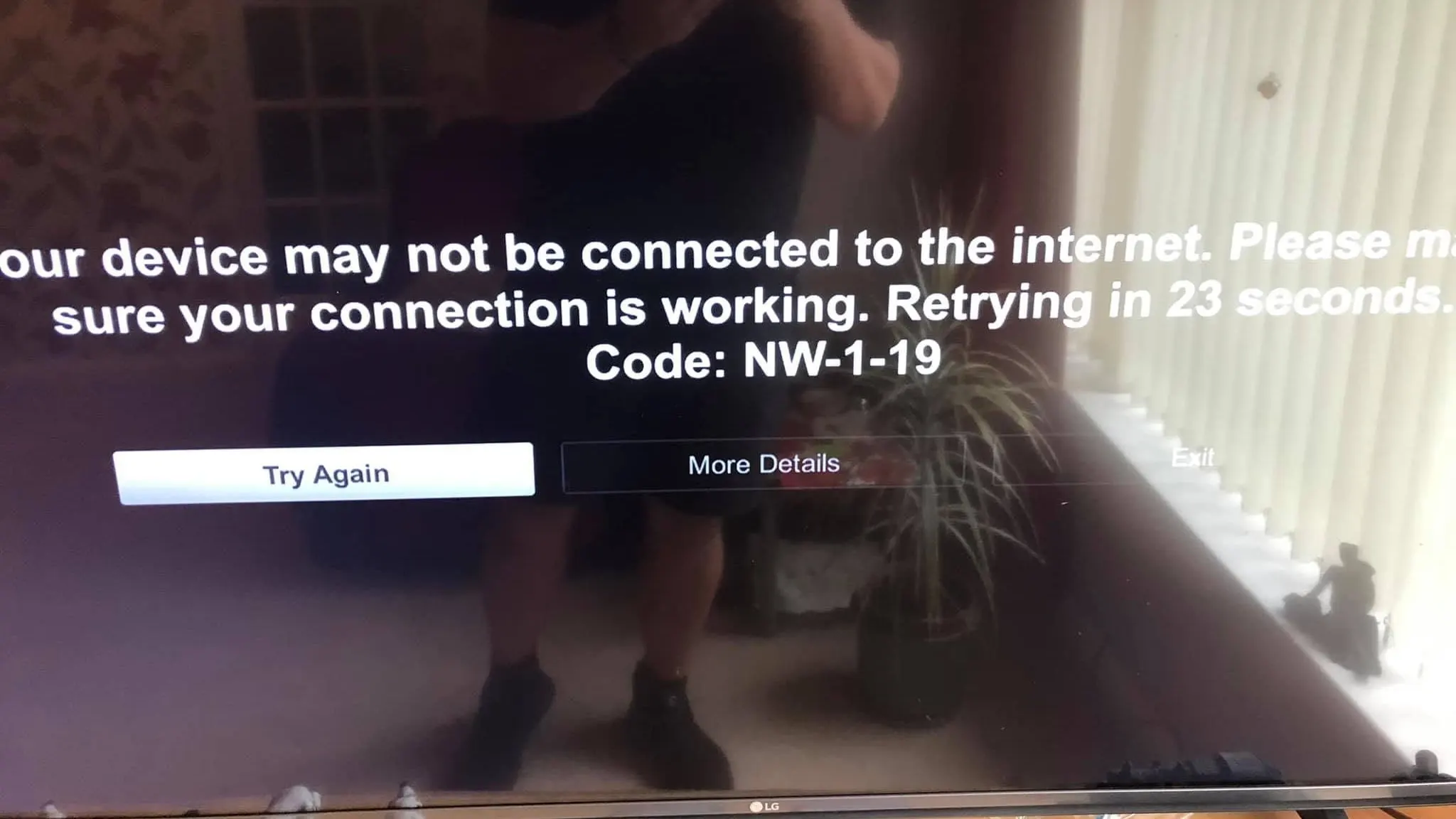New LG TV mounted on the wall during set-up, its screen showing a not connected to the internet message, code NW-1-19